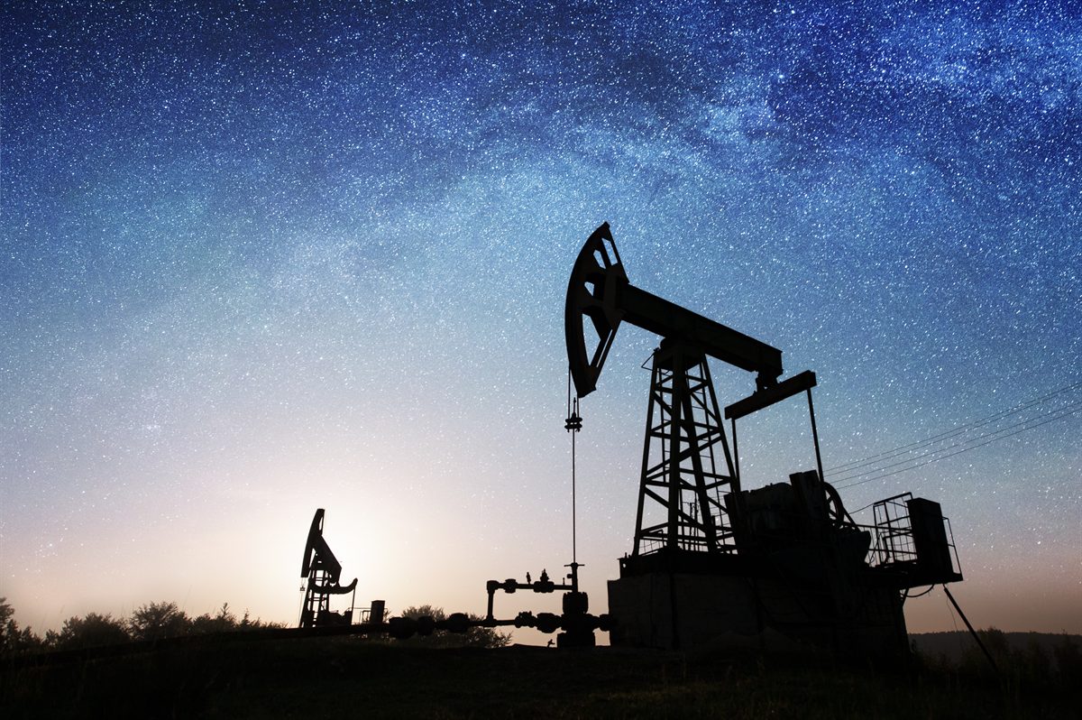 Oil pumpjacks silhouetted against a star-filled night sky